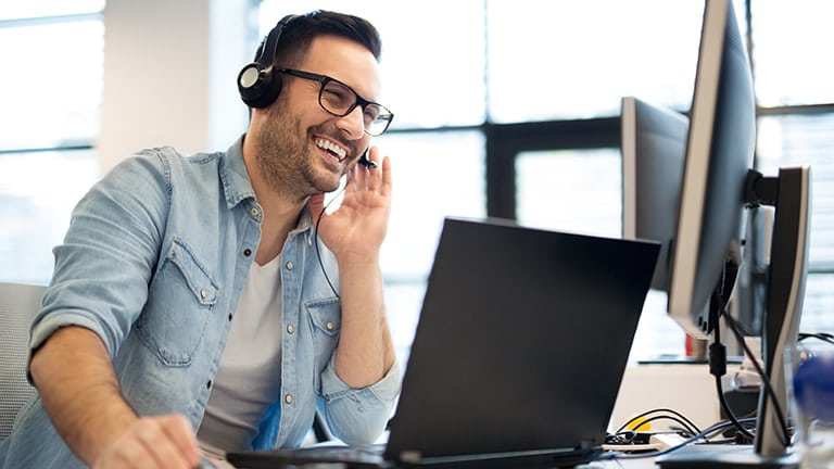 um homem sentado na frente de um computador conversando remotamente